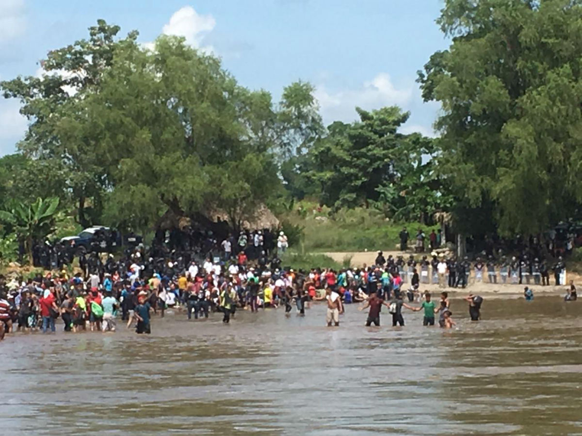 IMAGEN DEL DÍA | Migrantes forman cadena humana para cruzar el Río Suchiate